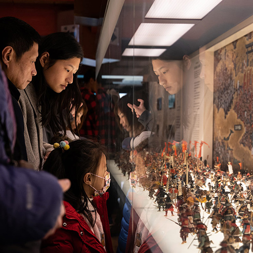 family watching science exhibit in a monter at the museum